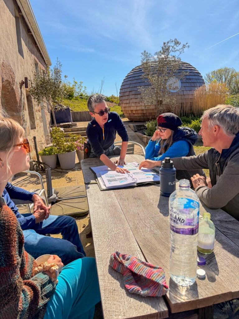 Group discussing around outdoor table with notebooks.