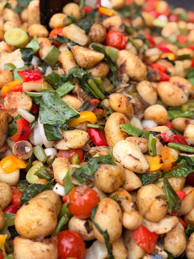 Sautéed gnocchi with vegetables, spinach, peppers, and leeks